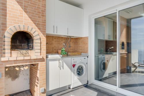 a kitchen with a washer and dryer next to a brick oven at Casa Morena by Atlantic Holiday in Santa Cruz