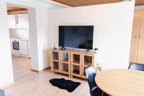un salon avec une table et une grande télévision dans l'établissement 1 BR apartment for 4 guests in Tórshavn, à Tórshavn