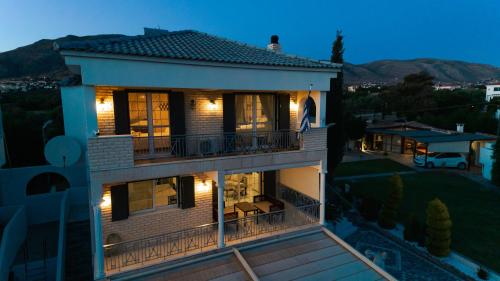 a large house with a balcony at night at Lagonisi Luxury Escape in Lagonissi