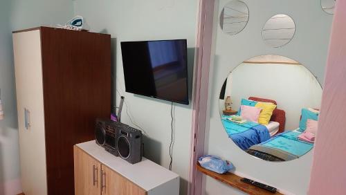 uma sala de estar com televisão e espelho em Аpartman ELENA em Rakovac