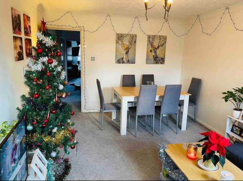 a christmas tree in a living room with a table and chairs at Beautiful One Bedroom Flat in London in Woodford Green
