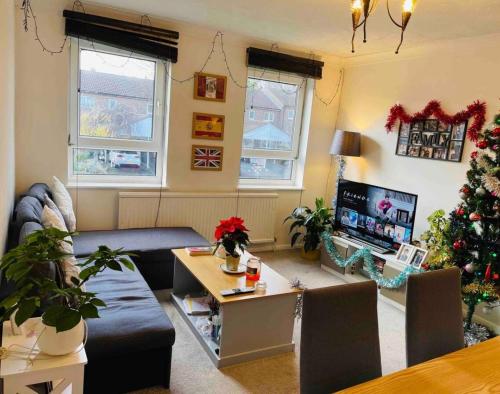 a living room with a christmas tree and a couch at Beautiful One Bedroom Flat in London in Woodford Green