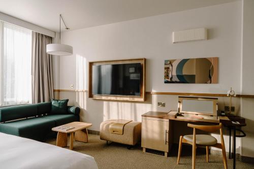 a hotel room with a bed and a couch and a desk at Club Quarters Hotel St Paul's, London in London