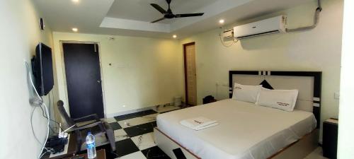 a bedroom with a bed and a ceiling fan at Srirathna Temple View Inn in Thanjāvūr