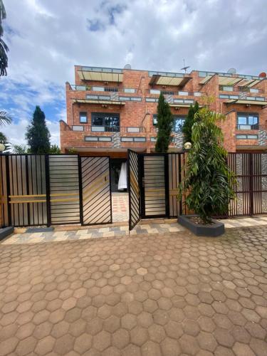 a brick building with a gate and a potted plant at Explore Iwacu Stay in Kigali