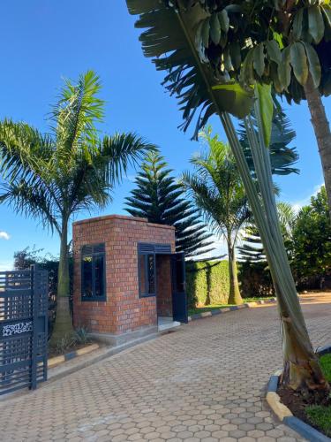 a brick building on a street with palm trees at Explore Iwacu Stay in Kigali