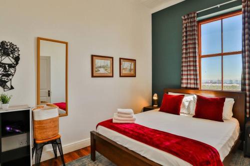 a bedroom with a bed and a large window at Quirky 2 Bed Home Parking Wi-Fi Backup Power in Cape Town