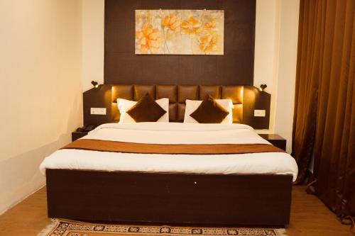 Postel nebo postele na pokoji v ubytování Hotel Siddhi Vinayak Regency, Mg Marg