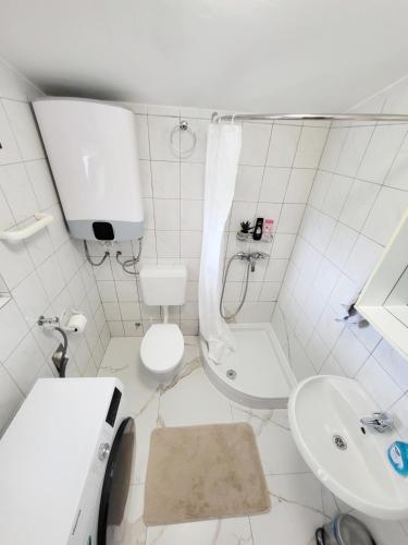 a white bathroom with a toilet and a sink at Apartment Loli - Nin in Nin