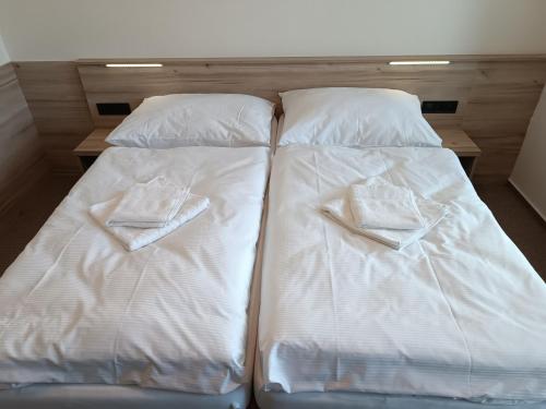 two beds with white sheets and towels on them at Hotel Bečva na Horní Bečvě in Horní Bečva