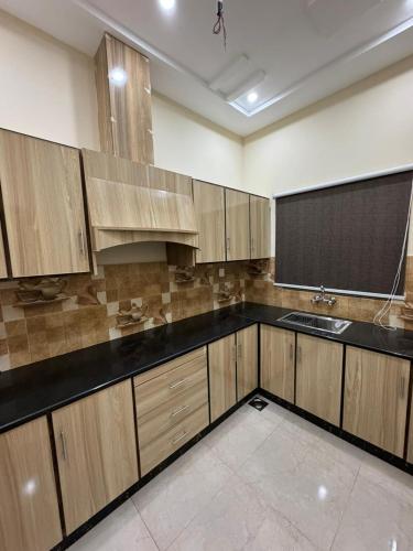 a large kitchen with wooden cabinets and a sink at Gold Pine Hotel Lahore in Lahore