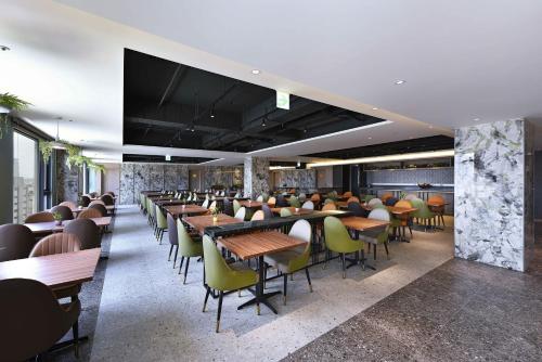 a restaurant with tables and chairs in a room at Fullon Poshtel - Kaohsiung in Kaohsiung