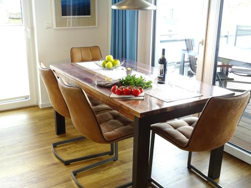 a dining room table with a bowl of fruit and a bottle of wine at Gode Wind Quartiere 7 in Dahme
