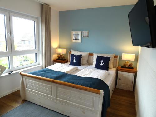 a bedroom with a bed with blue sheets and pillows at Gode Wind Quartiere 7 in Dahme