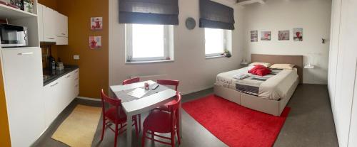 ein kleines Zimmer mit einem Bett, einem Tisch und Stühlen in der Unterkunft Appartamenti il borgo papavero in Busca