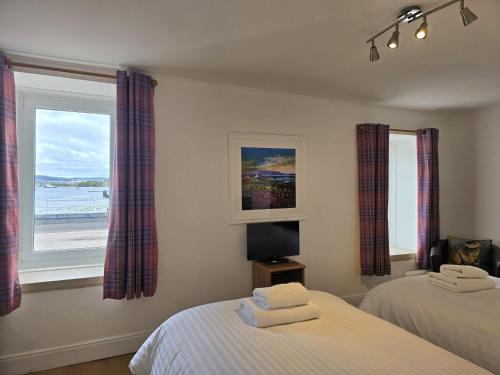 a bedroom with two beds and a window at Carnaburg Guesthouse in Tobermory