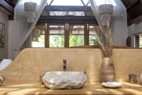 a bathroom with a large stone sink on a table at Vaayu Kula mandrem in Mandrem