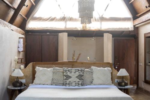 a bedroom with a large bed with pillows at Vaayu Kula mandrem in Mandrem