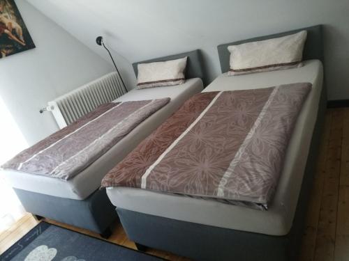 two beds sitting next to each other in a room at Endes Dreiseithof - Apartment in Schliengen