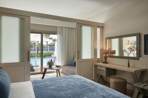 a hotel room with a bed and a desk and a desk at Atlantica Aeneas Resort in Ayia Napa