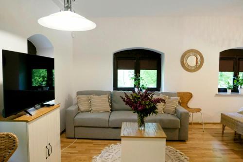 ein Wohnzimmer mit einem Sofa und einem TV in der Unterkunft Leśne Echo in Kazimierz Dolny