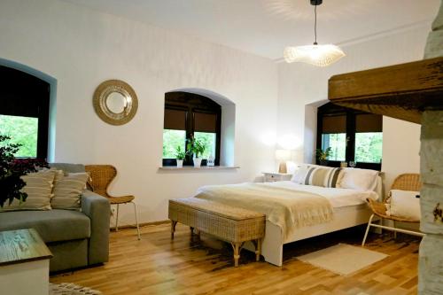 ein Schlafzimmer mit einem Bett, einem Sofa und Fenstern in der Unterkunft Leśne Echo in Kazimierz Dolny