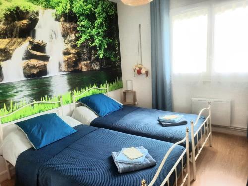 2 camas en una habitación con un cuadro en la pared en GITE CHEZ MONETTE, en Nance