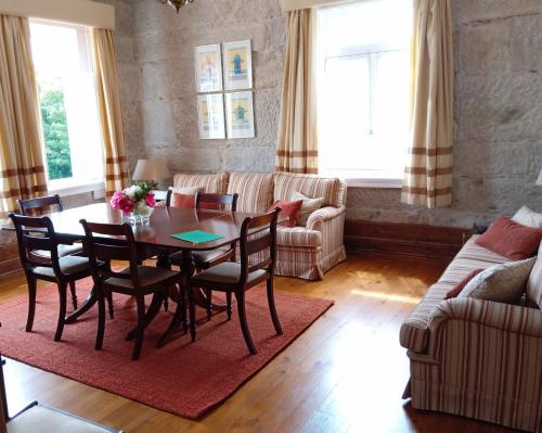 ein Wohnzimmer mit einem Tisch, Stühlen und einem Sofa in der Unterkunft Casa Pita Caminha in Caminha