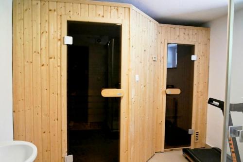 a bathroom with a wooden wall with two doors at Leśne Echo in Kazimierz Dolny