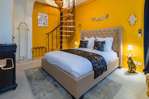 a bedroom with a large bed with yellow walls at La Flûte enchantée in Troyes