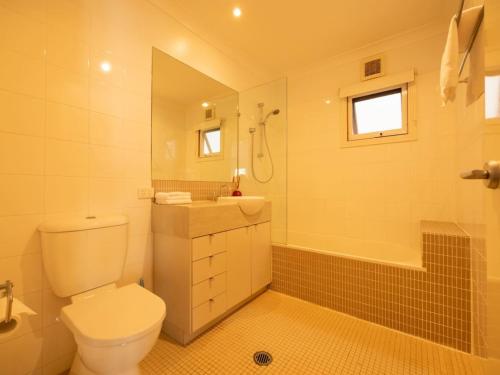 a bathroom with a toilet and a sink and a shower at 6KM to CBD Convenient 5BR Queenslander Coorparoo in Brisbane