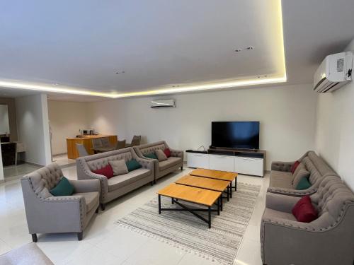 شاليهات حائط حجري في الرياض: غرفة معيشة مع كنب وطاولة وتلفزيون
