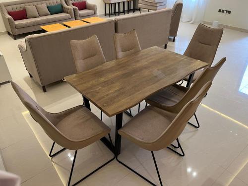 شاليهات حائط حجري في الرياض: طاولة وكراسي خشبية في الغرفة