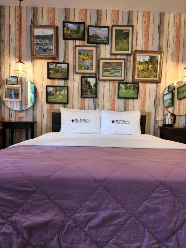 a bed in a room with pictures on the wall at 墾丁牧場Villa Kenting Pasture - Villa B&B in Kenting