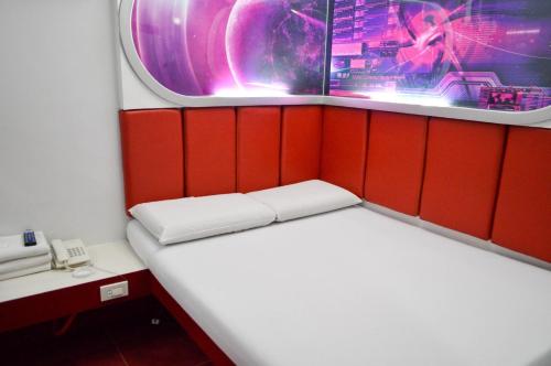a small room with a bed and a phone at Astrotel Avenida in Manila