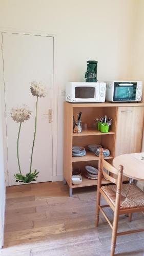 - un salon avec une table et un four micro-ondes dans l'établissement STUDIO MEUBLE DINARD RDC DROITE, à Dinard