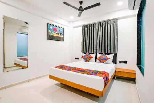 een slaapkamer met een bed en een raam bij FabHotel Royal King I in Surat