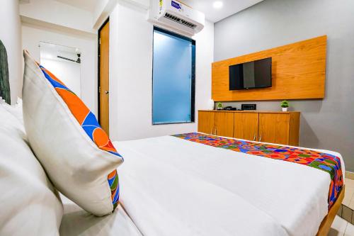 una camera con letto e TV di FabHotel Royal King I a Surat