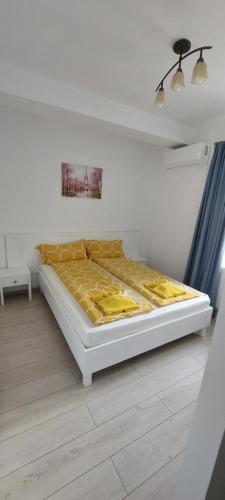 Un dormitorio con una cama con una manta amarilla encima. en Apartamente 9 Sofia, en Băile Felix