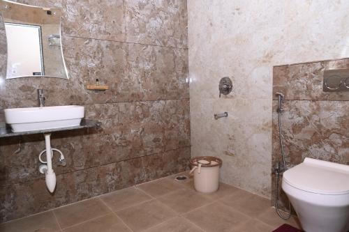 a bathroom with a sink and a toilet at Varaha Residency Lodging and Banquet in Hubli