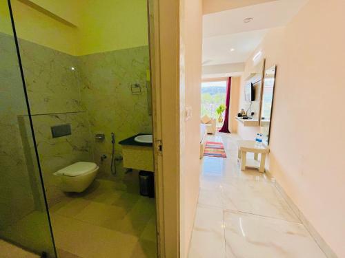 een badkamer met een toilet en een glazen douche bij Spring Sky - A Four Star Luxury Hotel in Rishīkesh