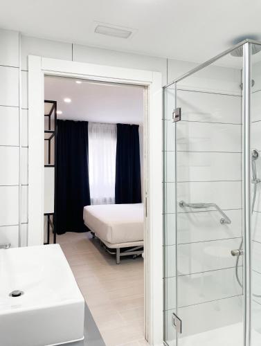 a bathroom with a bed and a glass shower at Four Rooms in Muxia