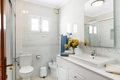 a white bathroom with a toilet and a sink at Casa Cactus in Haría