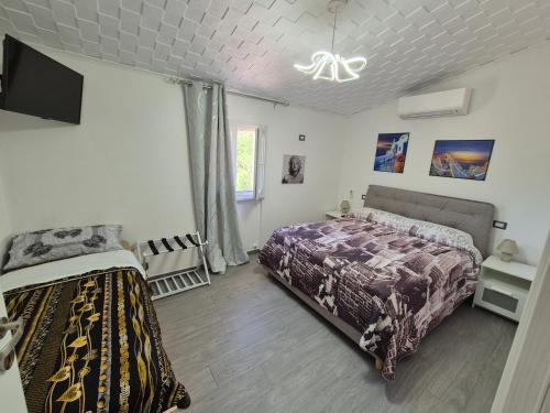 - une chambre avec un lit et une télévision à écran plat dans l'établissement Casa Vacanze Villa DaLu con piscina, à Itri