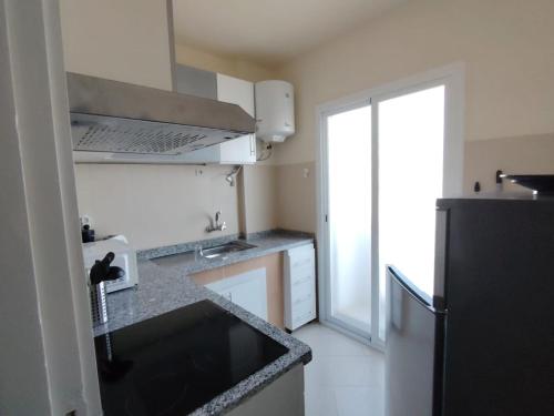 a small kitchen with a sink and a refrigerator at Appartement Sofia in Martil