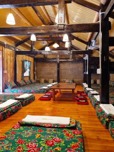 a large room with many beds in it with a table at Mam Da Homstay in Na Hang