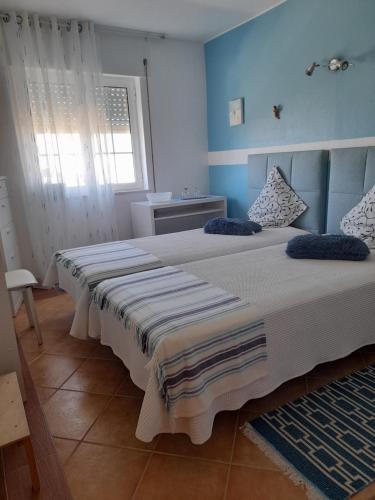 1 dormitorio con 2 camas y paredes azules en Casa Da Anita en Sagres