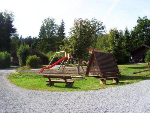 a park with a playground with a slide and benches at Komfortables-Ferienblockhaus-Nr-27-56-qm-bis-4-Personen-Viechtach-Jaegerpark in Viechtach