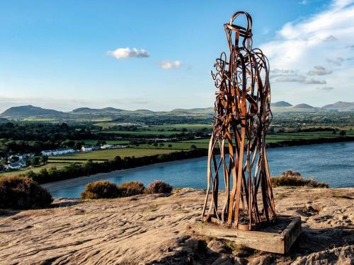 una escultura de metal sentada en la cima de una colina en Heddfan - Peaceful Studio 5 mins from Stunning Llanbedrog Beach, en Pwllheli