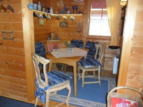 a dining room with a table and chairs in a cabin at Komfortables-Ferienblockhaus-Nr-27-56-qm-bis-4-Personen-Viechtach-Jaegerpark in Viechtach